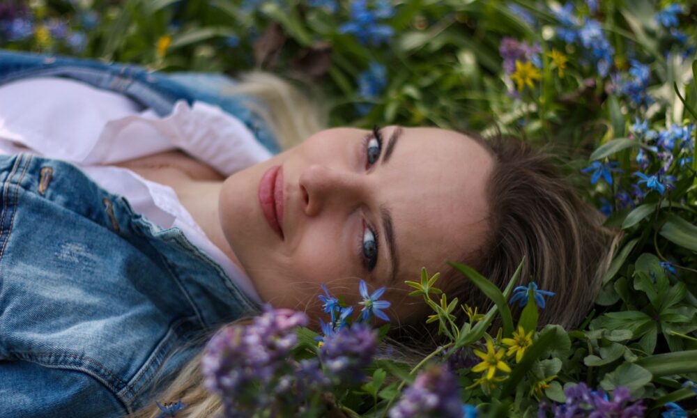 woman lying down in field of flowers