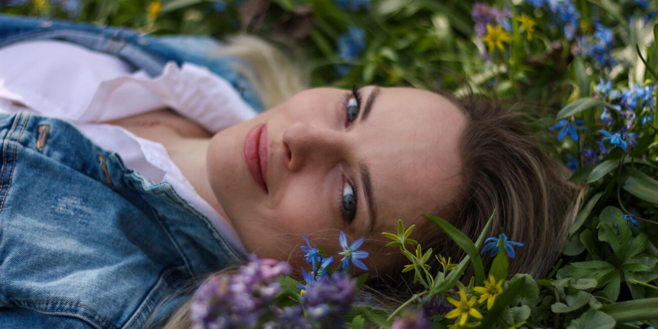 woman lying down in field of flowers