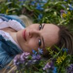 woman lying down in field of flowers