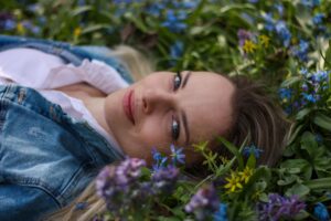woman lying down in field of flowers