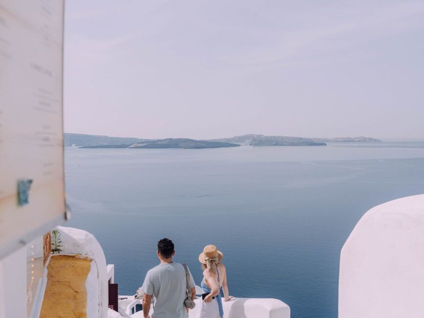 couple walking down the stairs in santorini greece