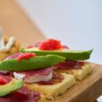 close up of gourmet avocado toasts with toppings