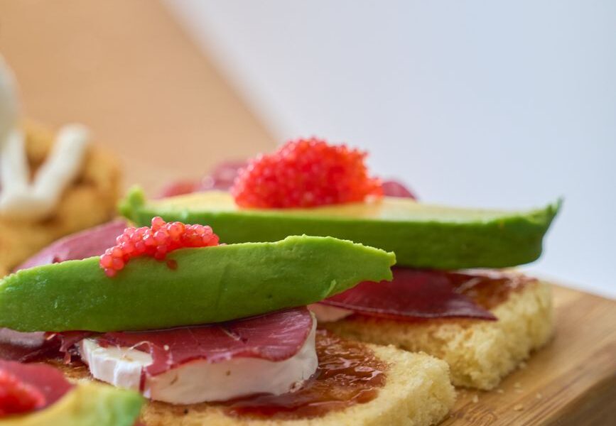 close up of gourmet avocado toasts with toppings