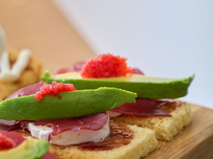 close up of gourmet avocado toasts with toppings
