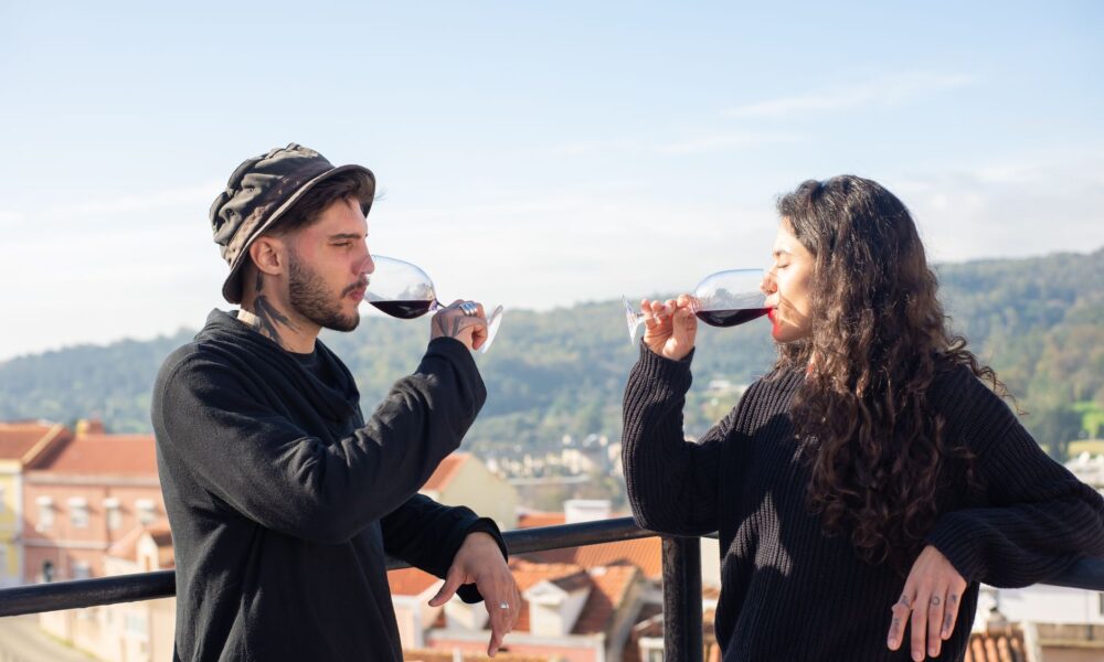 man and woman wearing black long sleeves drinking red wine