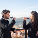man and woman wearing black long sleeves drinking red wine