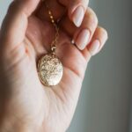 close up shot of a person holding a gold pendant