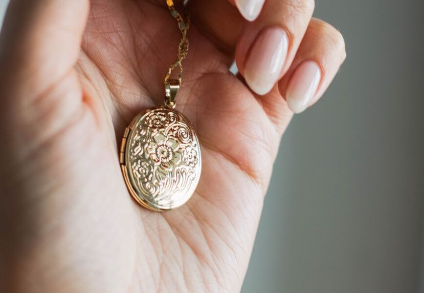 close up shot of a person holding a gold pendant